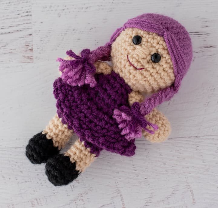 crochet doll with purple dress and pink hair