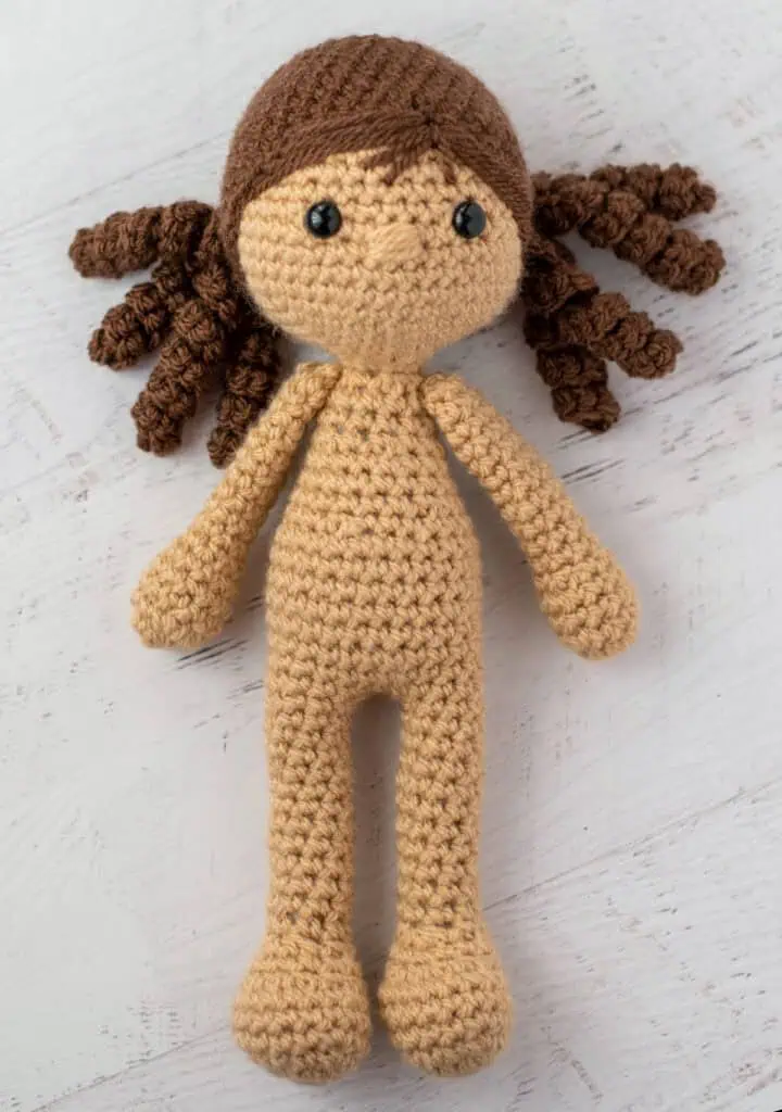 crochet doll with brown hair laying