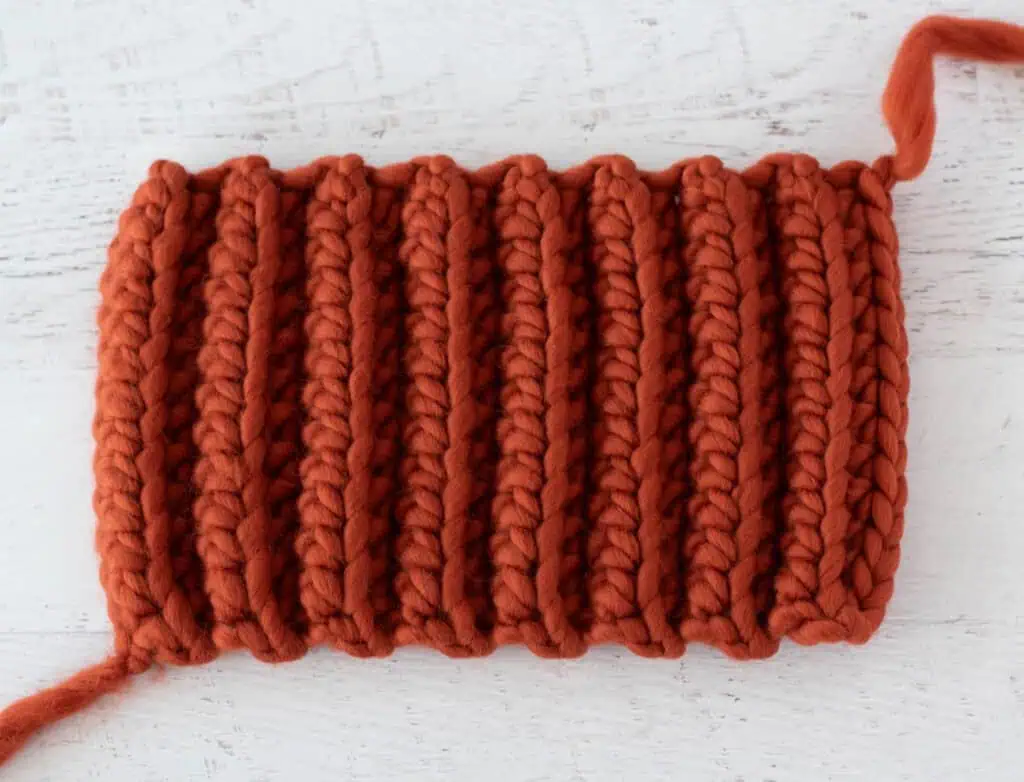 Orange crochet rectangle on white wood table